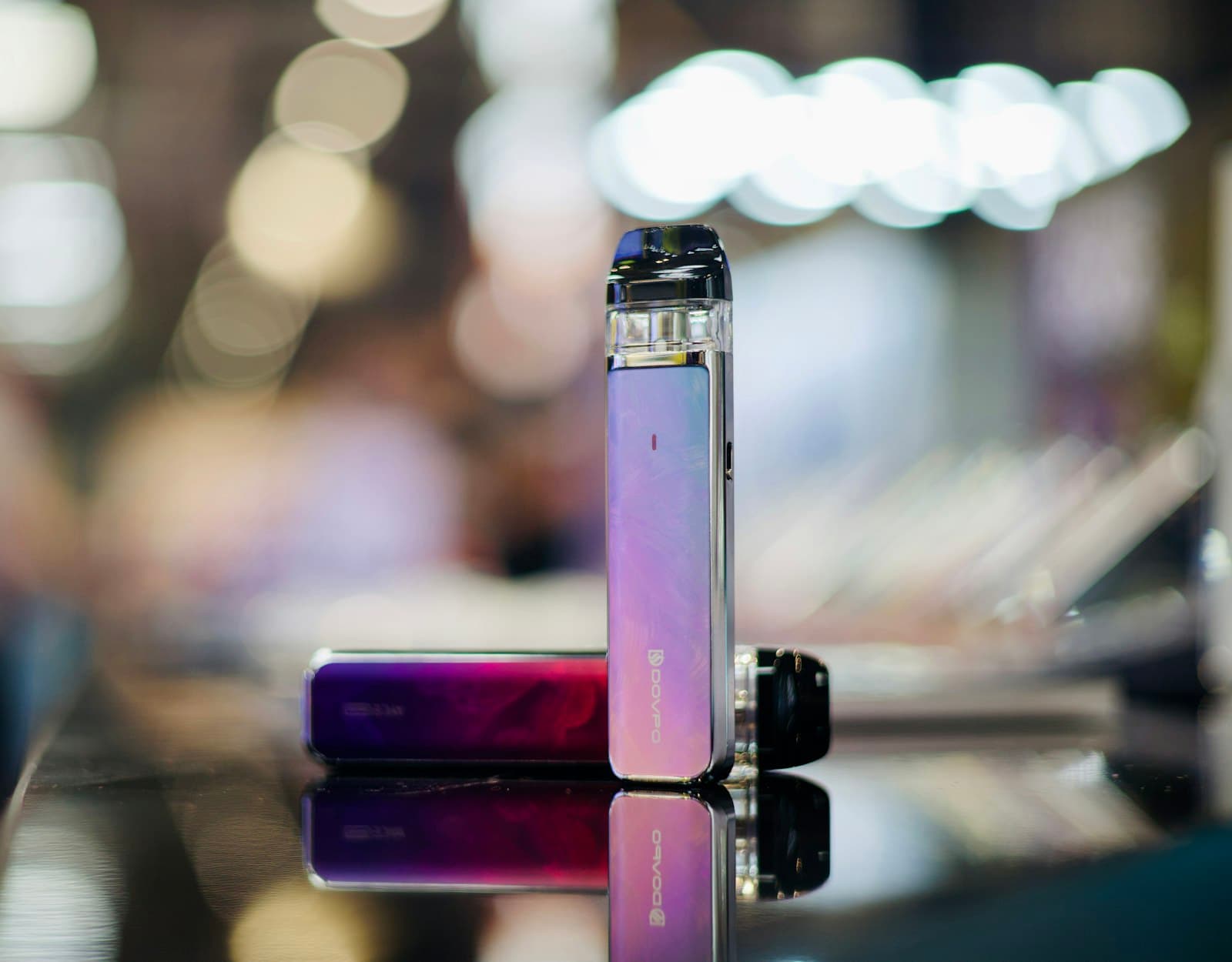 Two different vape devices placed side by side on a table for comparison